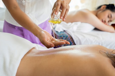 Pouring massage oil onto the hand in preparation for massage