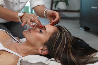 Women lying on the floor with the cushion under her neck during head massage