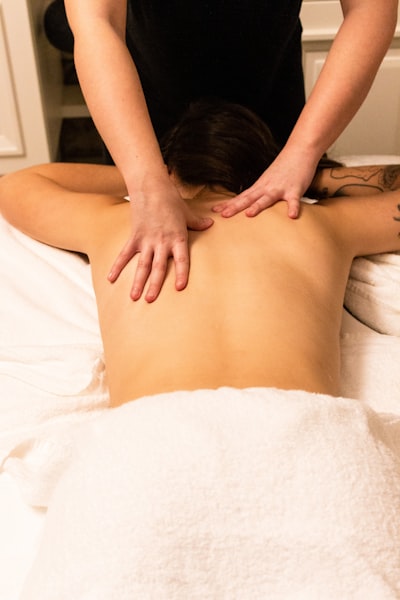 Woman is being massaged by the man wearing black T-shirt