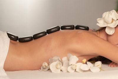 Woman is relaxing on the massage table with hot stones on her back