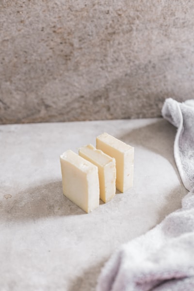 Three slices of the Shea butter on the table with white towel in the background