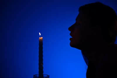 Man blowing out tapper candle