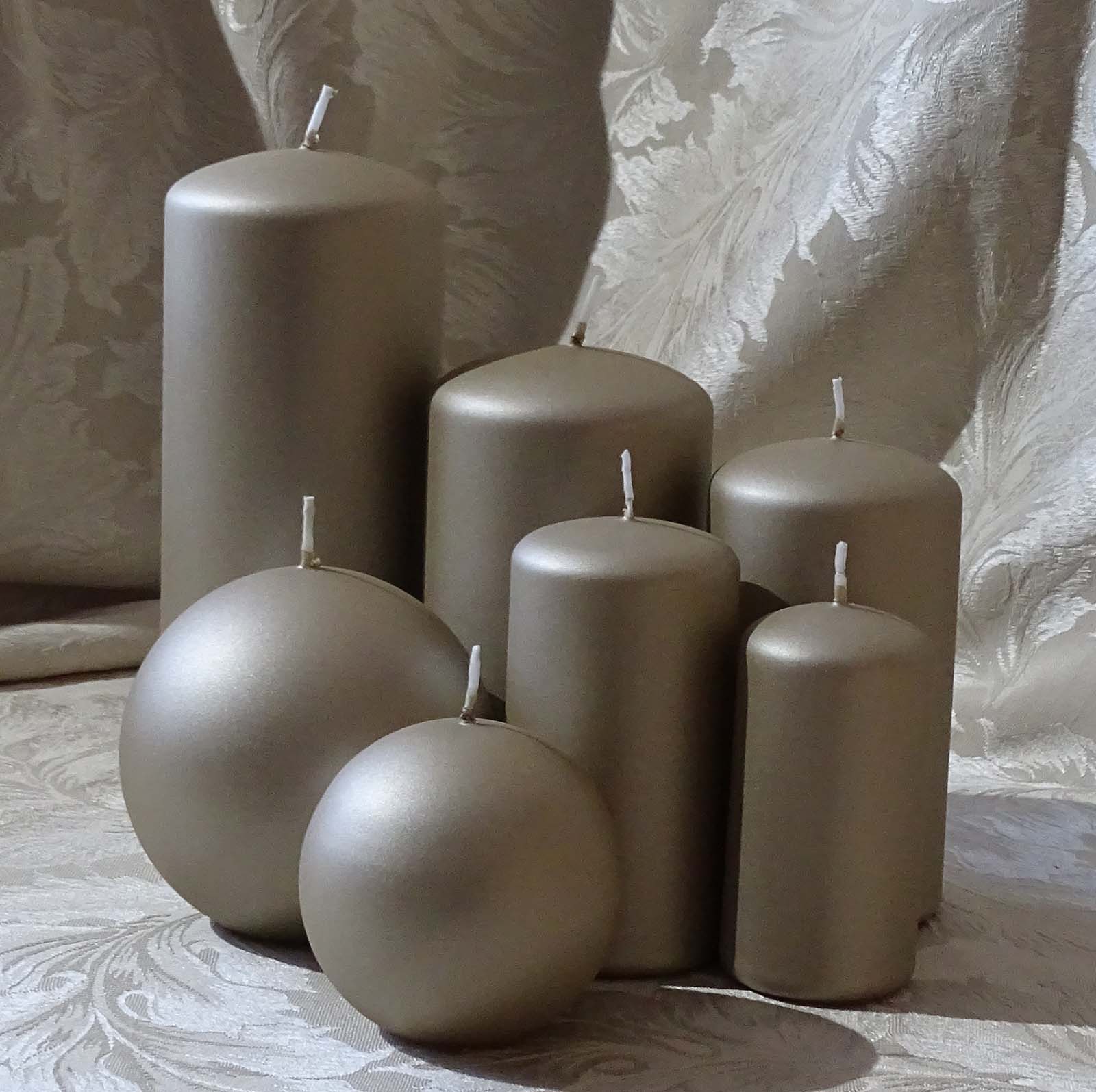 Five pillar and two round candles in champagne colour sitting on the cream and silver cable cloth