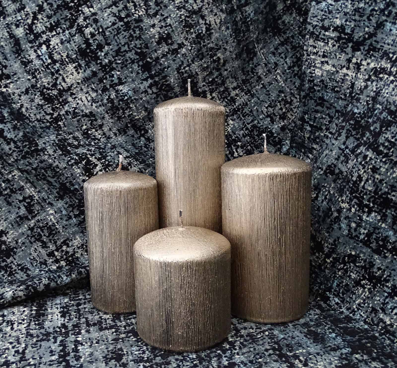 Four different size copper pillar candles in the black and white scenery