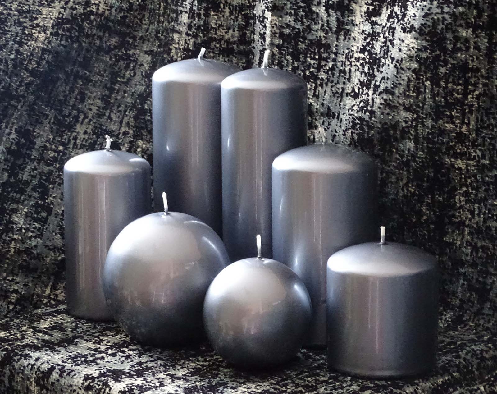 Five pillar and two round silver candles grouped together