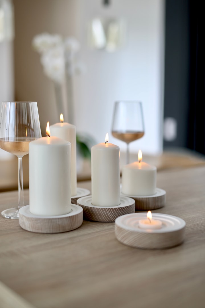 Wooden coffee table with two glasses of wine and five candles 