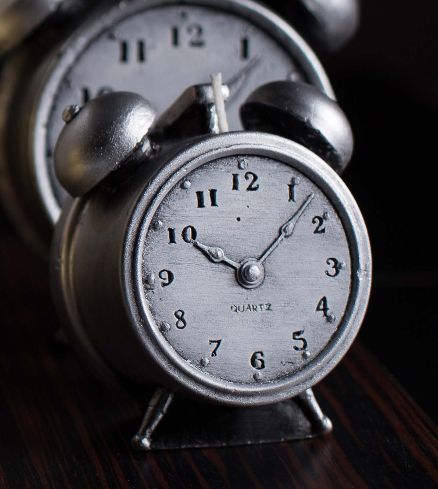Two candles shaped as vintage alarm clock in silver colour 
